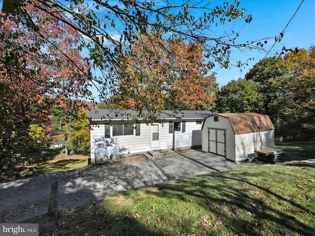 view of front of home featuring a shed, a patio area, and a front lawn