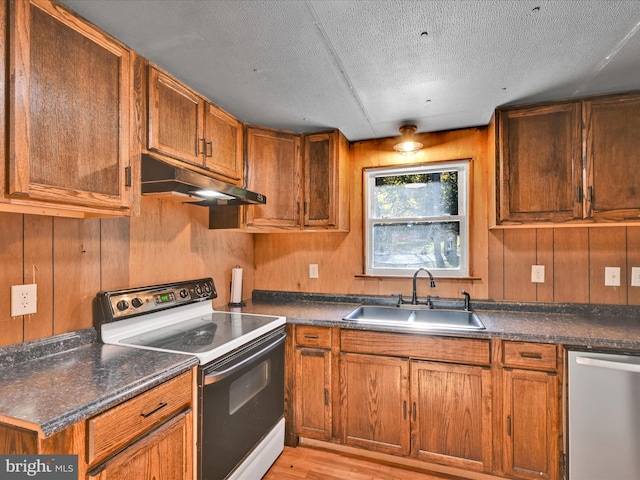 kitchen featuring wood walls, dishwasher, white electric stove, and sink