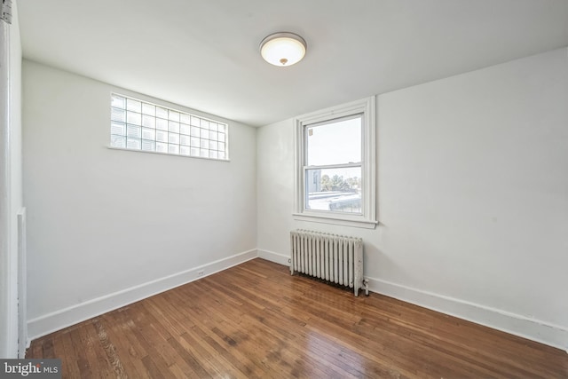 unfurnished room featuring hardwood / wood-style flooring and radiator