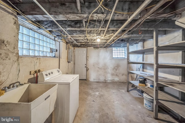 basement with plenty of natural light, sink, electric panel, and washer / clothes dryer