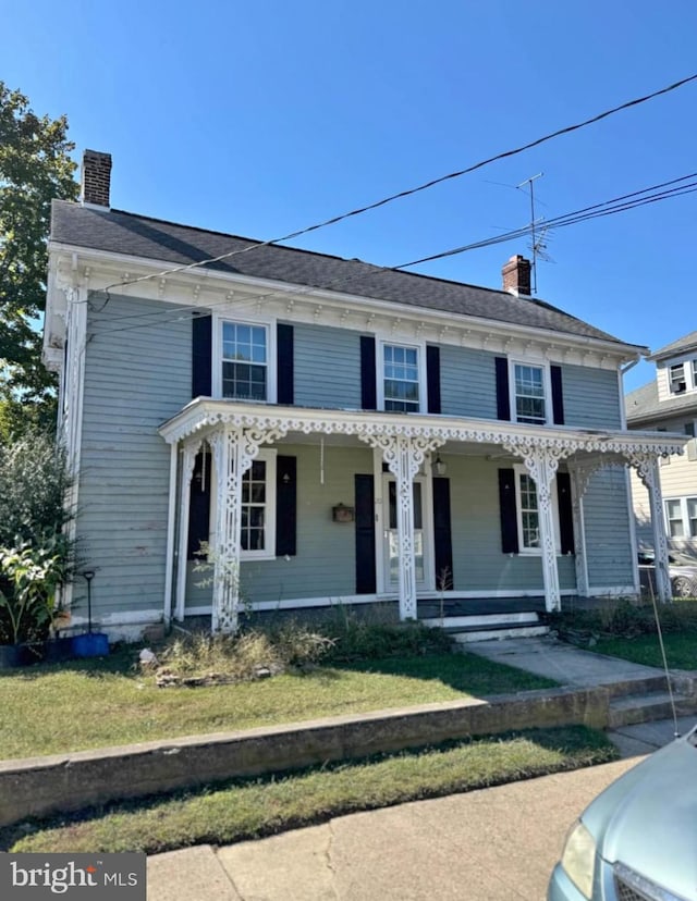 view of front facade featuring covered porch and a front yard