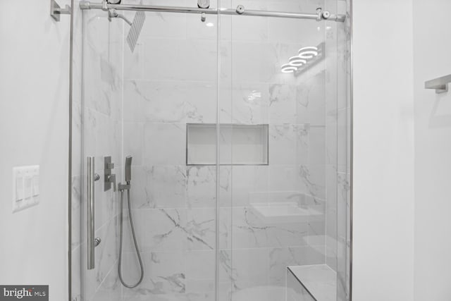 bathroom with a shower with door