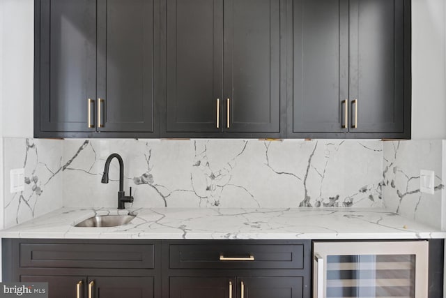 kitchen featuring gray cabinets, light stone counters, sink, and wine cooler