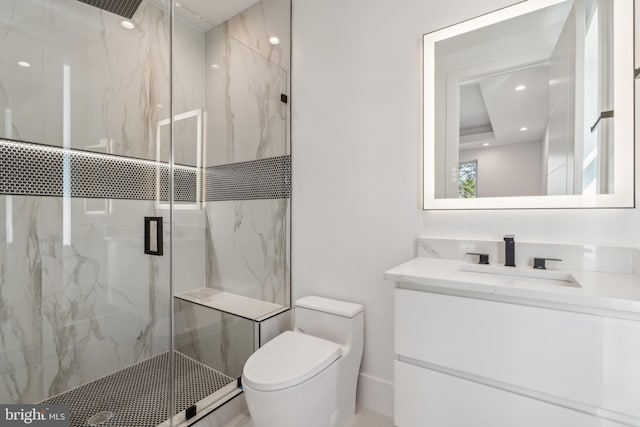 bathroom featuring vanity, a shower with shower door, and toilet