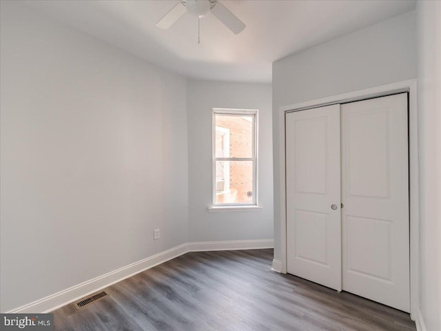 unfurnished bedroom featuring wood-type flooring, a closet, and ceiling fan