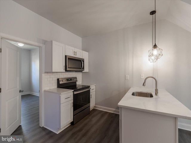 kitchen featuring dark wood-type flooring, stainless steel appliances, sink, decorative light fixtures, and white cabinets