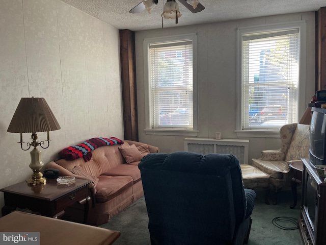 living area featuring a textured ceiling, radiator, carpet, and ceiling fan