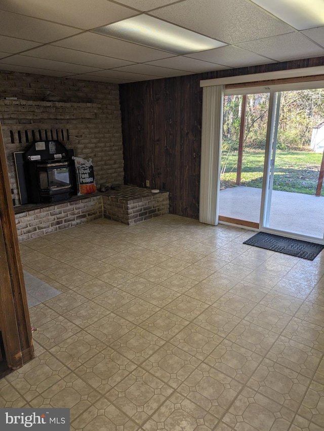 basement with wooden walls and a drop ceiling