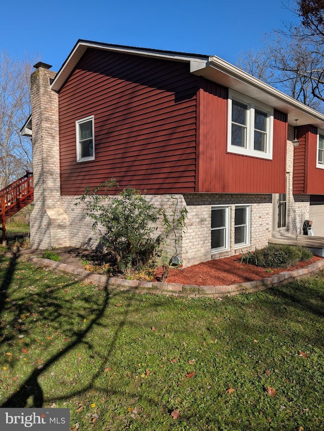 view of side of home with a yard