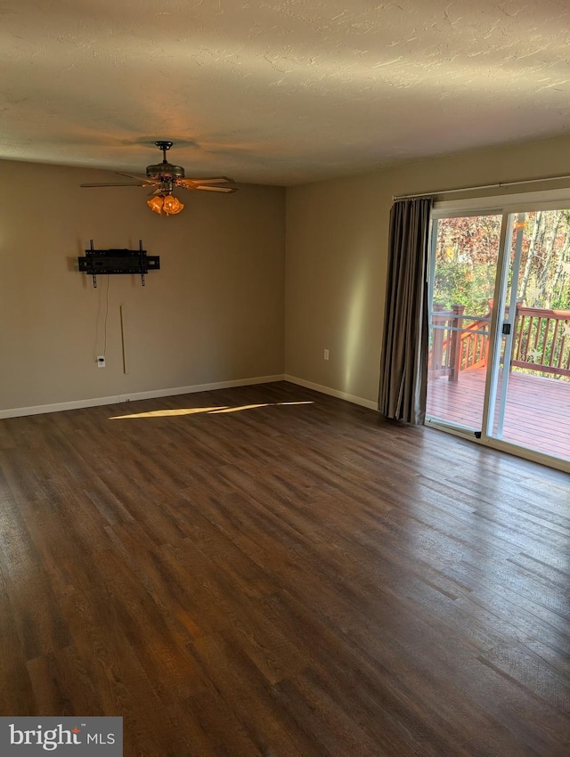 spare room with a textured ceiling, dark wood-type flooring, and ceiling fan