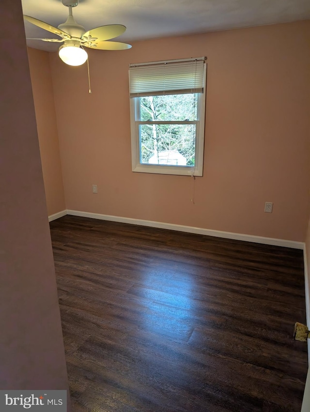 empty room featuring dark wood-type flooring and ceiling fan