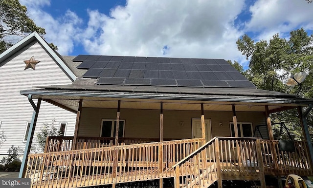31 S Jersey Ave, Dorothy, NJ 08317 - rear view of property with roof mounted solar panels, roof with shingles, and a deck