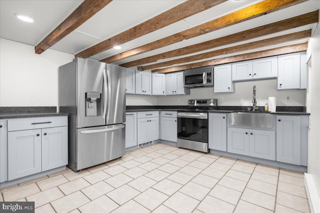 kitchen featuring beam ceiling, stainless steel appliances, and sink