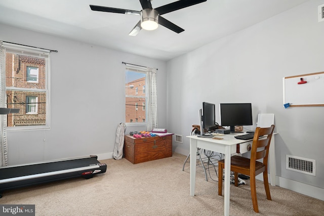 carpeted home office featuring ceiling fan