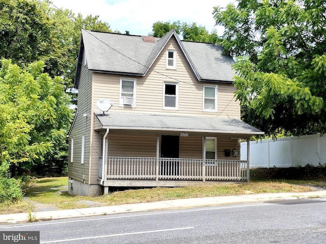 view of front of property with fence, covered porch, and cooling unit