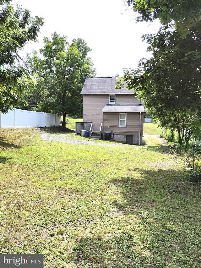 view of yard featuring central air condition unit and fence
