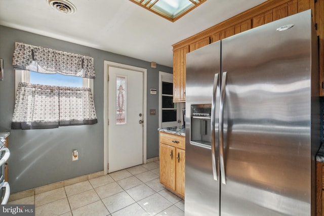 kitchen featuring light stone counters, stainless steel appliances, and light tile patterned floors