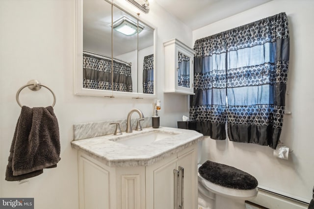 bathroom featuring vanity, toilet, and a baseboard heating unit