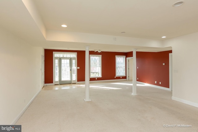 carpeted spare room featuring decorative columns