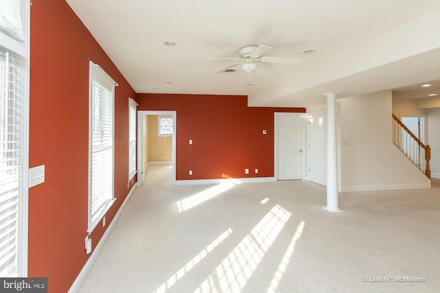 unfurnished room featuring decorative columns, light carpet, and ceiling fan