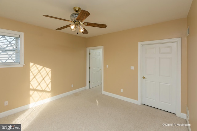 spare room with light colored carpet and ceiling fan