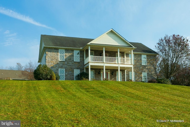 view of front facade with a balcony and a front lawn