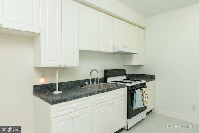 kitchen featuring gas range, light tile patterned floors, sink, and white cabinets