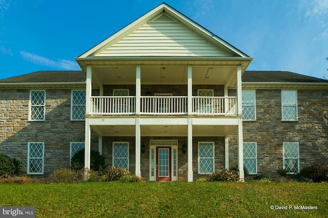 view of front of property with a balcony and a front yard