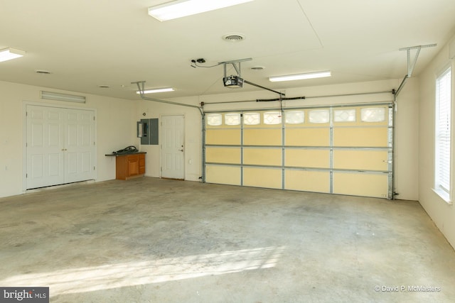 garage with a garage door opener and electric panel