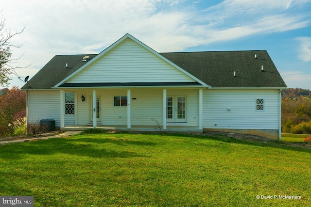 rear view of property featuring a yard and cooling unit