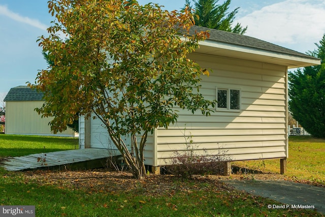 view of home's exterior with a garage, an outdoor structure, and a lawn