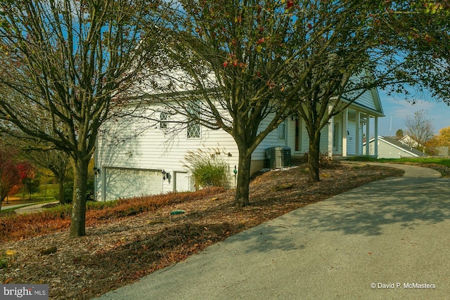 view of side of property with a garage and central AC unit