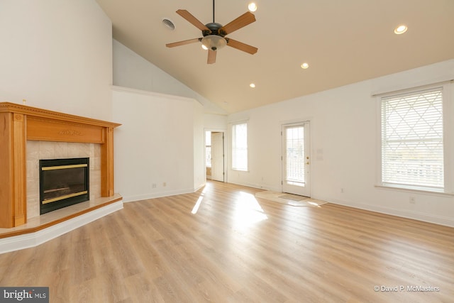 unfurnished living room featuring ceiling fan, a fireplace, high vaulted ceiling, and light wood-type flooring