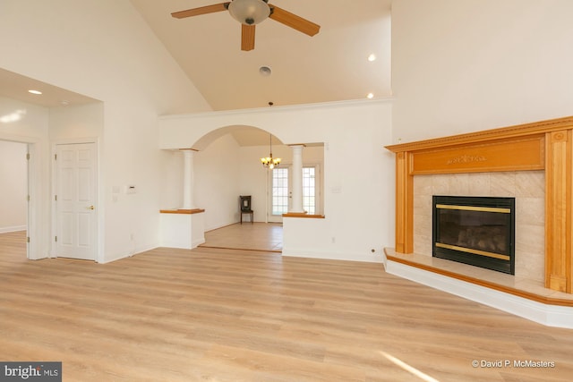 unfurnished living room featuring a fireplace, high vaulted ceiling, light hardwood / wood-style floors, and ceiling fan