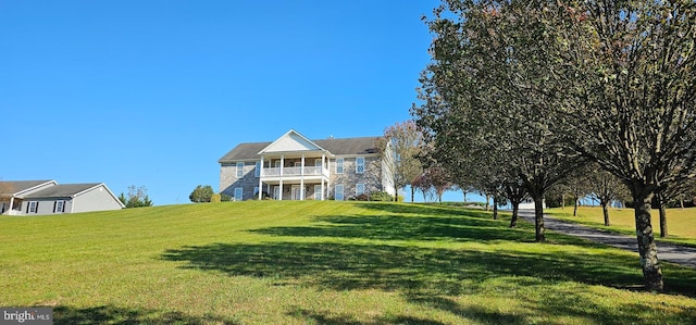 view of front facade with a balcony and a front yard