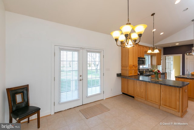 kitchen with french doors, decorative light fixtures, kitchen peninsula, and vaulted ceiling