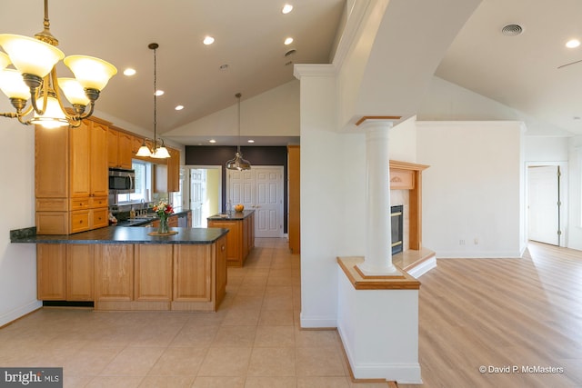 kitchen featuring decorative light fixtures, a fireplace, high vaulted ceiling, and kitchen peninsula