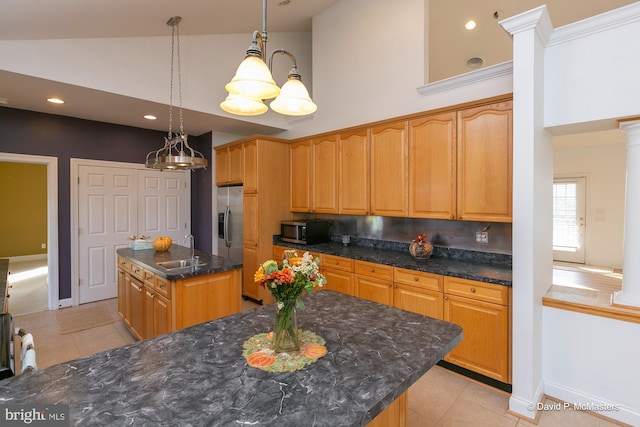 kitchen with high vaulted ceiling, sink, hanging light fixtures, a center island, and stainless steel appliances