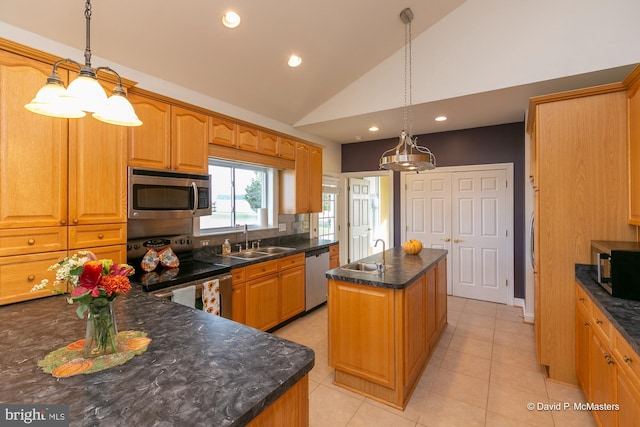 kitchen with pendant lighting, lofted ceiling, a center island, and appliances with stainless steel finishes