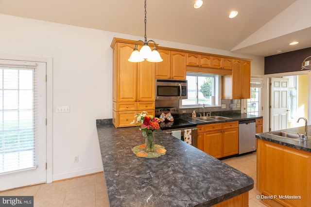 kitchen featuring tasteful backsplash, vaulted ceiling, appliances with stainless steel finishes, and sink