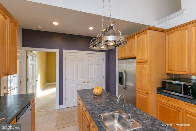 kitchen with light tile patterned flooring, appliances with stainless steel finishes, decorative light fixtures, sink, and dark stone counters