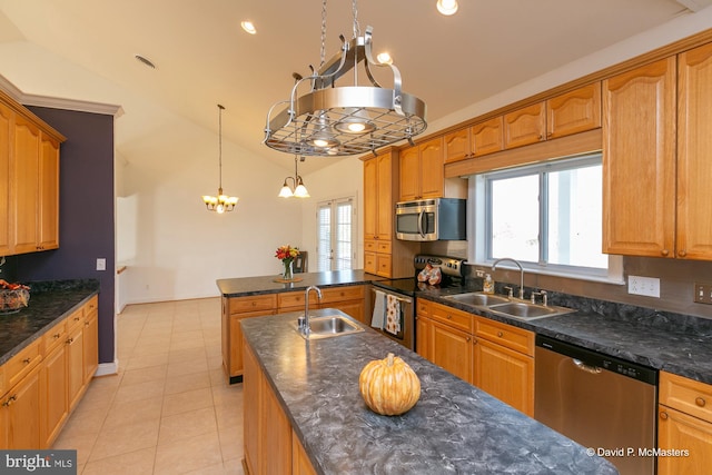 kitchen featuring lofted ceiling, sink, decorative light fixtures, and appliances with stainless steel finishes