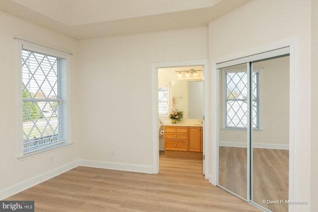 bedroom with light hardwood / wood-style floors and a closet