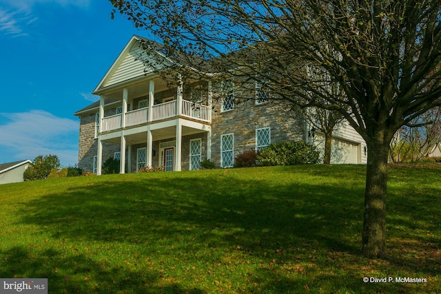 view of front of property with a garage, a front lawn, and a balcony