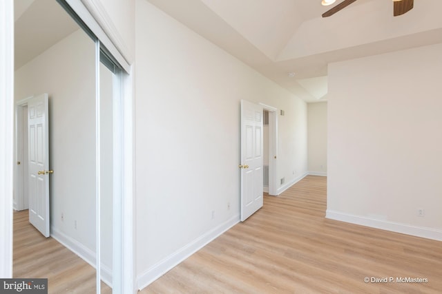 hallway with lofted ceiling and light hardwood / wood-style flooring