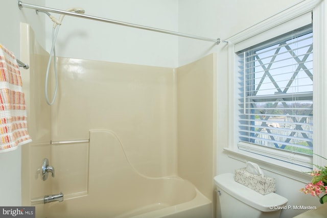 bathroom with bathtub / shower combination, toilet, and a healthy amount of sunlight