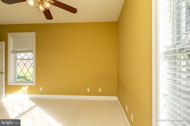 carpeted spare room featuring ceiling fan