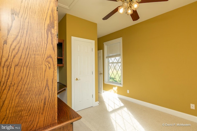 interior space featuring ceiling fan and light colored carpet