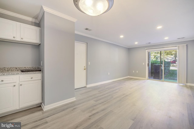 unfurnished living room with ornamental molding and light wood-type flooring