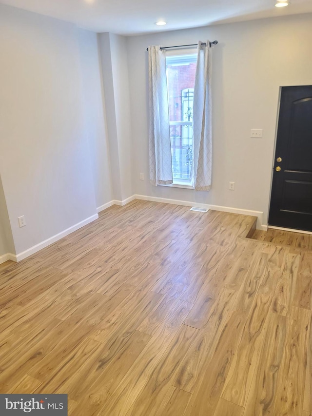 foyer with baseboards, wood finished floors, and recessed lighting